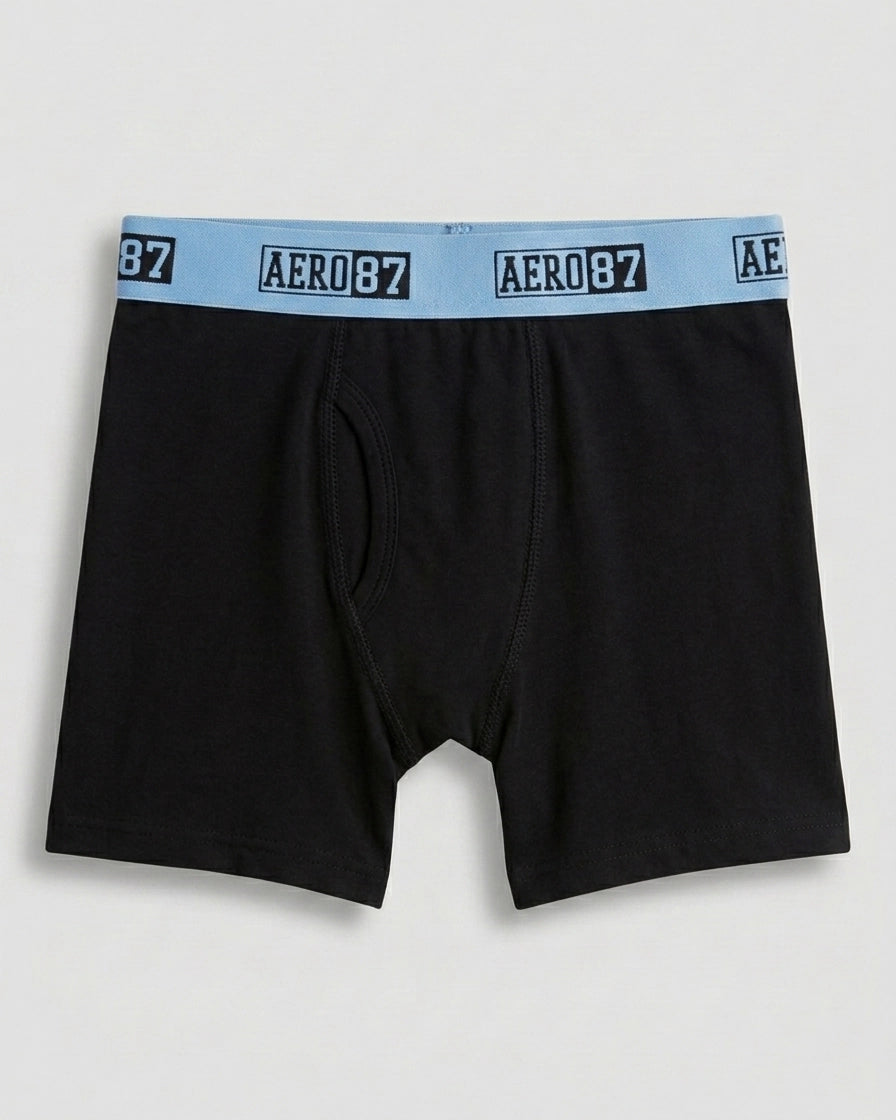 Boys' premium cotton boxer brief in solid black with sky-blue AERO 87 logo elastic waistband, flat lay front view