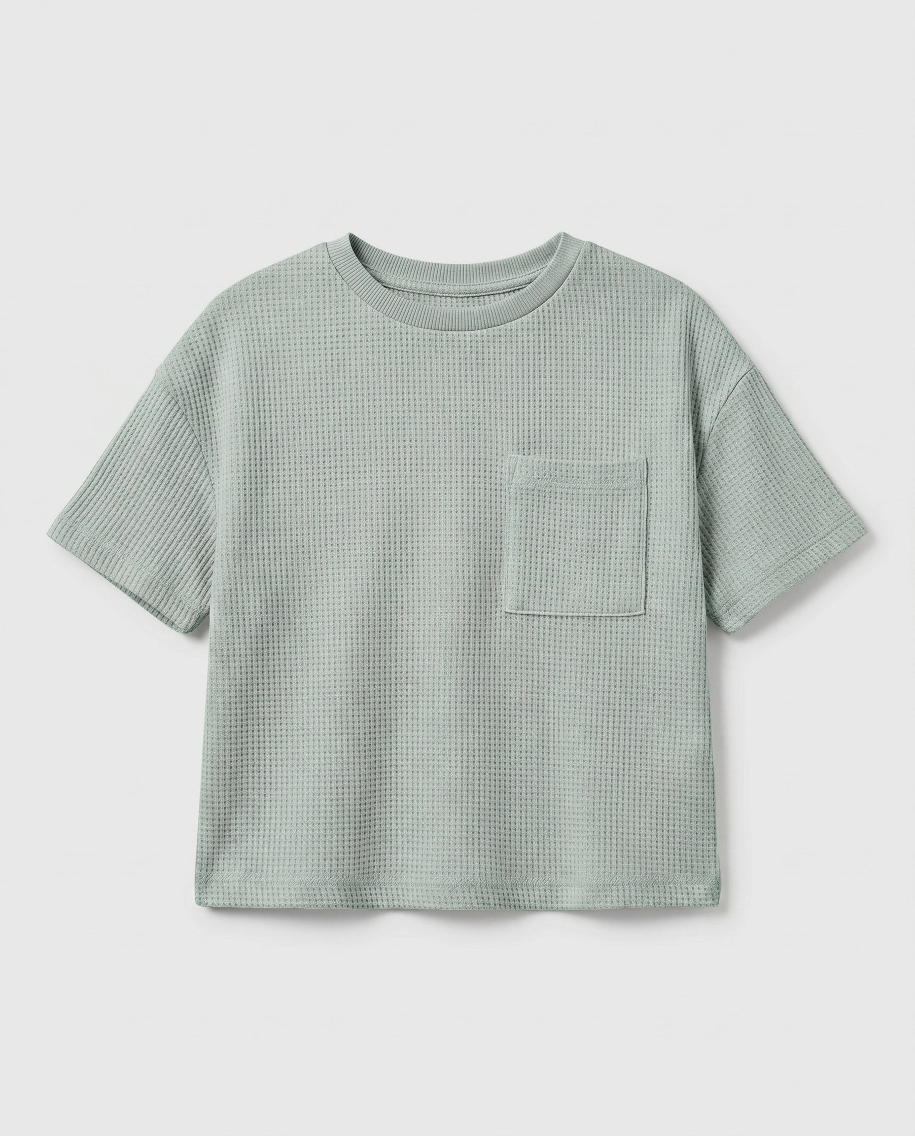 Boy's sage mint waffle cotton t-shirt with relaxed boxy fit, ribbed crewneck, and patch chest pocket, photographed flat on a soft grey backdrop.
