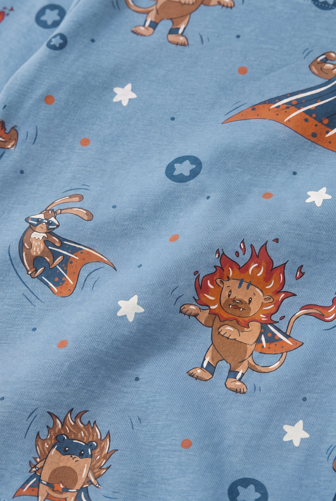 Close-up of superhero animal print with lion, rabbit and bear in capes on blue fabric, boys 2-piece set by PTex Fashion