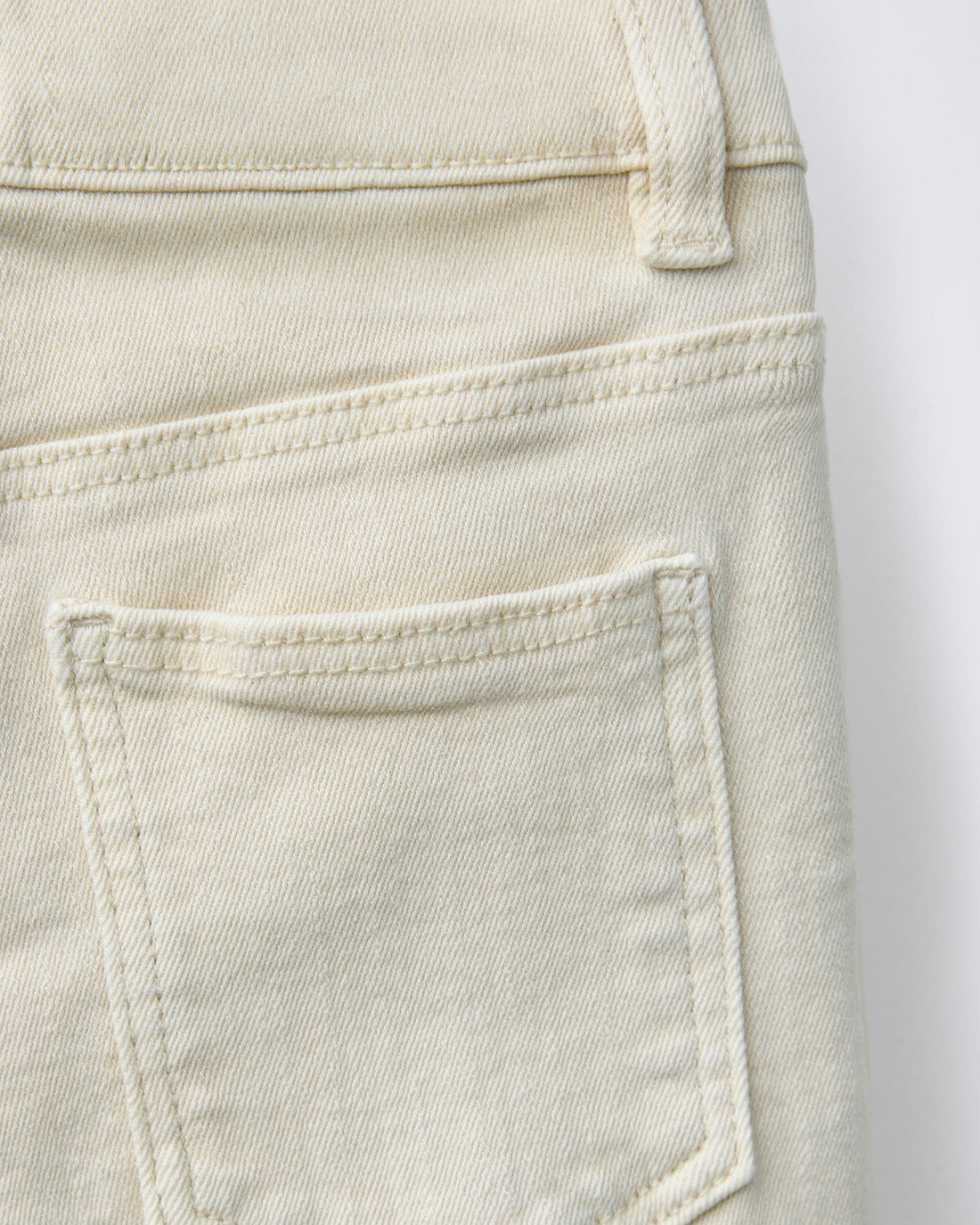 Ecru cream denim Bermuda shorts for boys, front view showing five-pocket styling, antique silver-tone shank button, zip fly, and belt loops on natural undyed cotton denim.