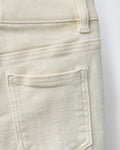 Close-up of back patch pocket on ecru cream boys' denim Bermuda shorts, showing tonal topstitching detail and soft natural cotton denim texture.