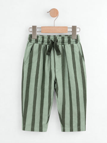 PTex Fashion sage and forest green striped kids' trousers on a wooden hanger