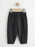 Black fleece joggers with elastic waist and side pockets on a wooden hanger - PTex Fashion