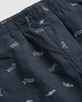 Close-up of navy blue cotton twill fabric with white airplane print and elastic waistband detail on boys' shorts