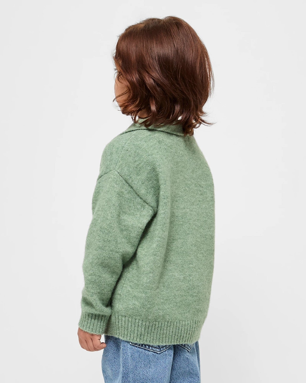 children wearing a sage green sweater on a white background