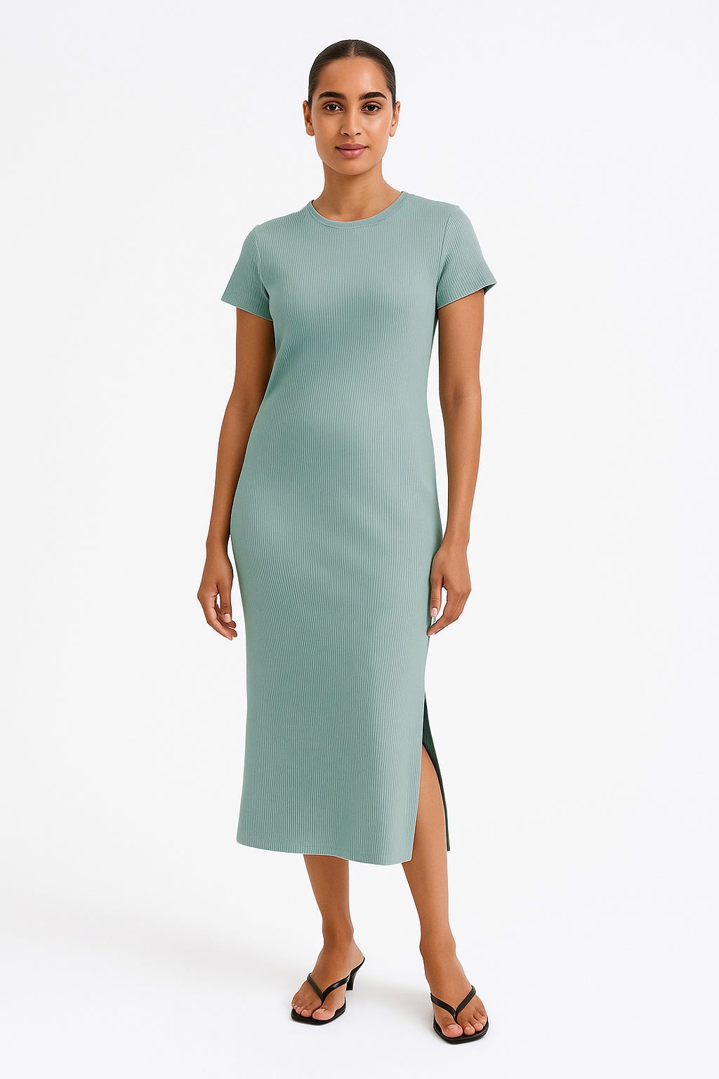 Woman wearing a dark mint midi dress with a slit on a white background