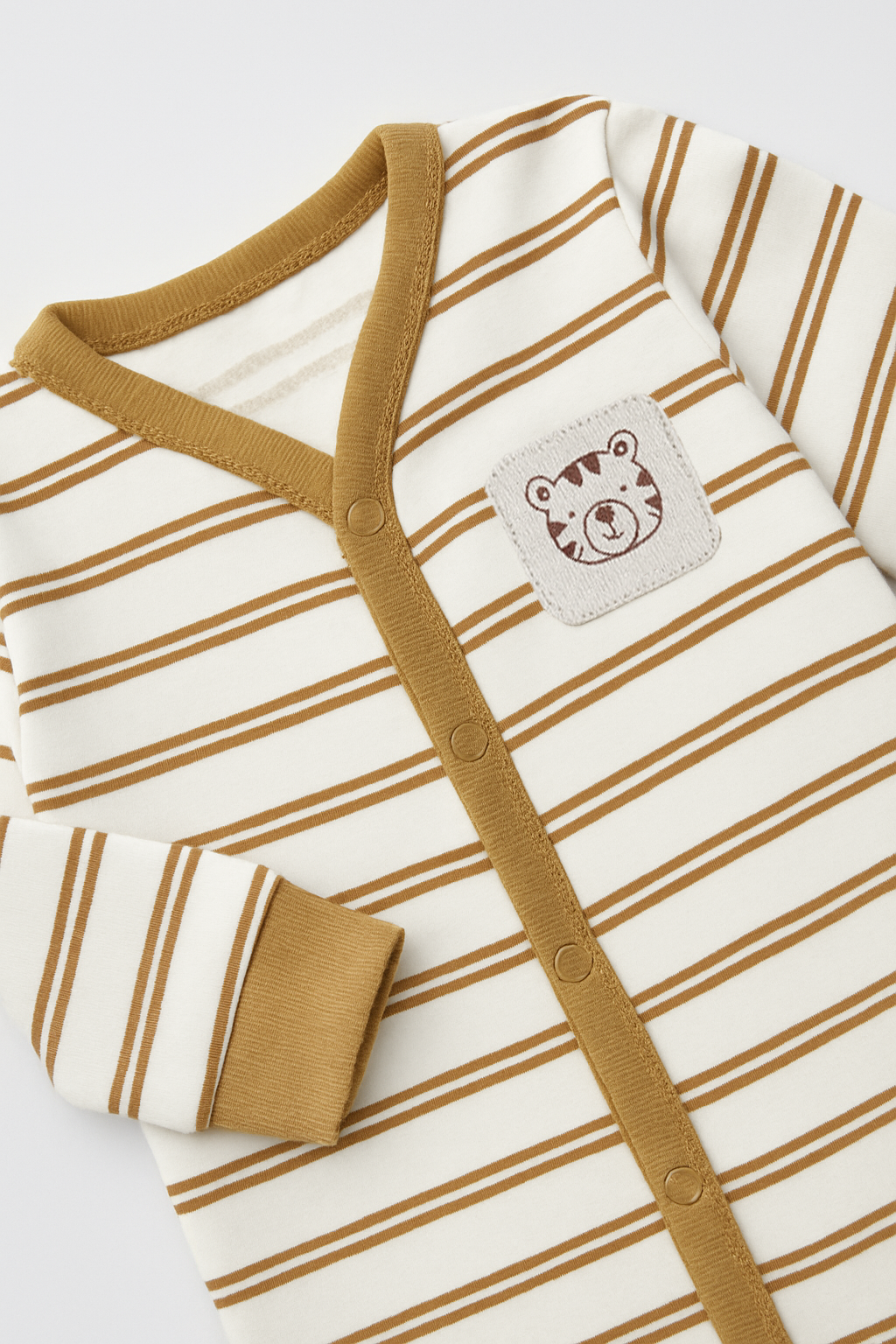 Striped baby onesie with a small patch on a white background