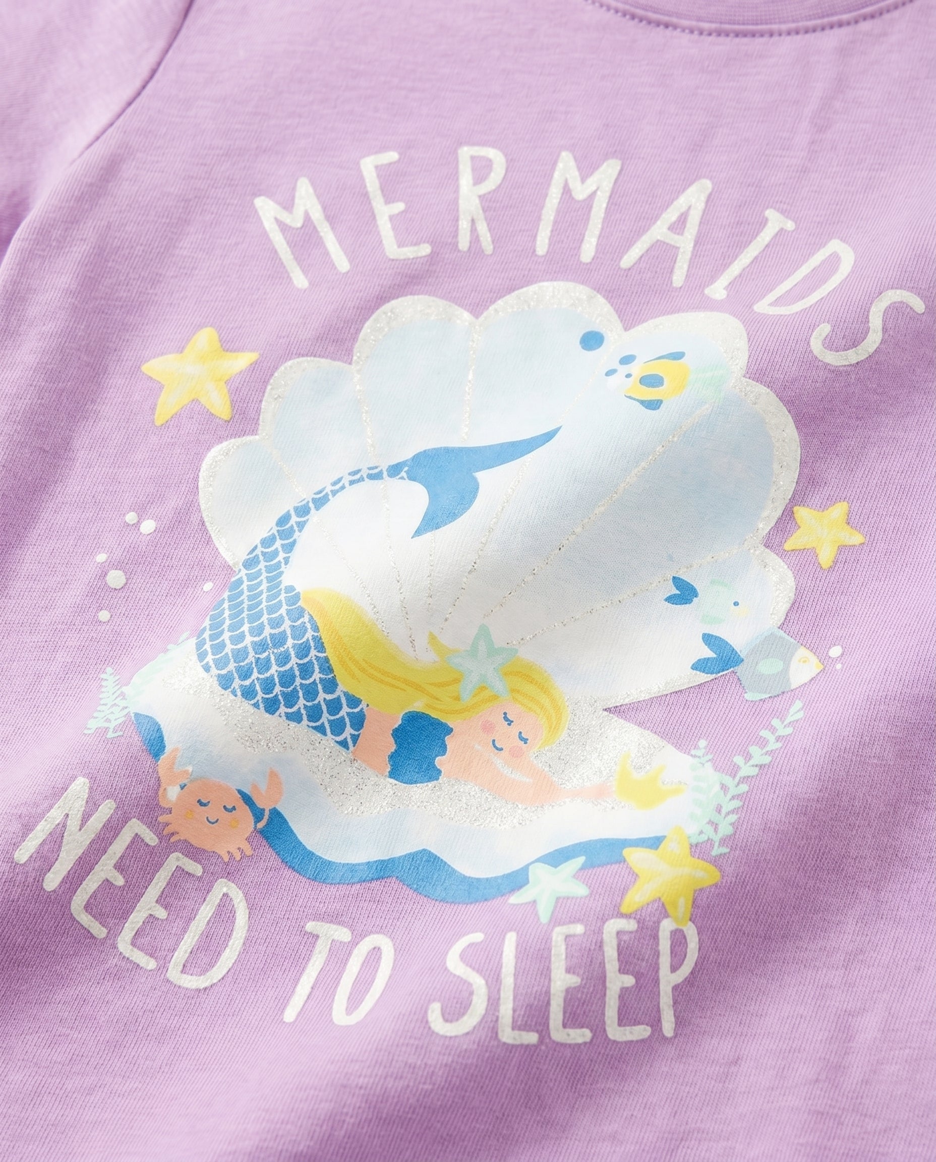Close-up of sleepy mermaid, crab, starfish and seashell glitter print on purple girls' cotton tee