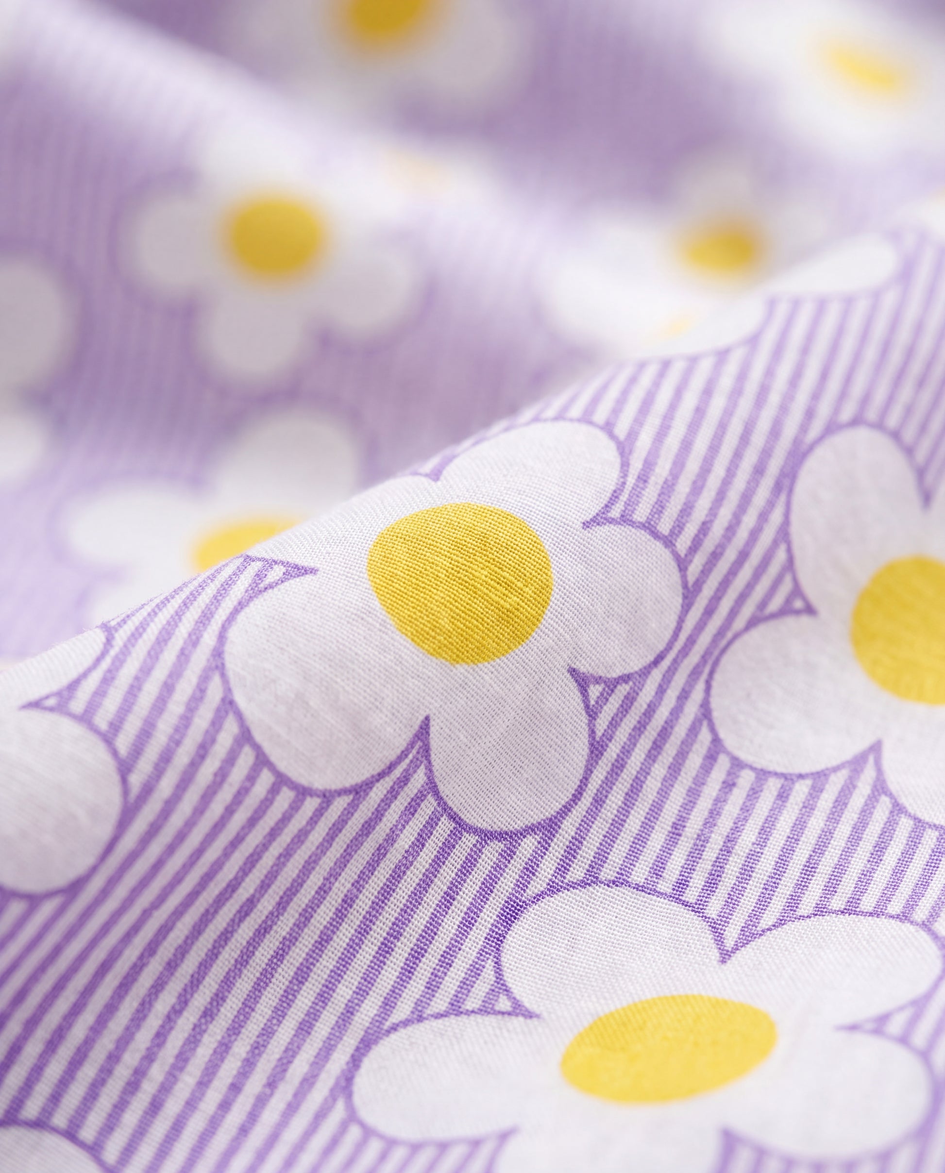 Close-up of PTex Fashion girls' cotton set fabric showing lilac pinstripe with white daisy and yellow floral print
