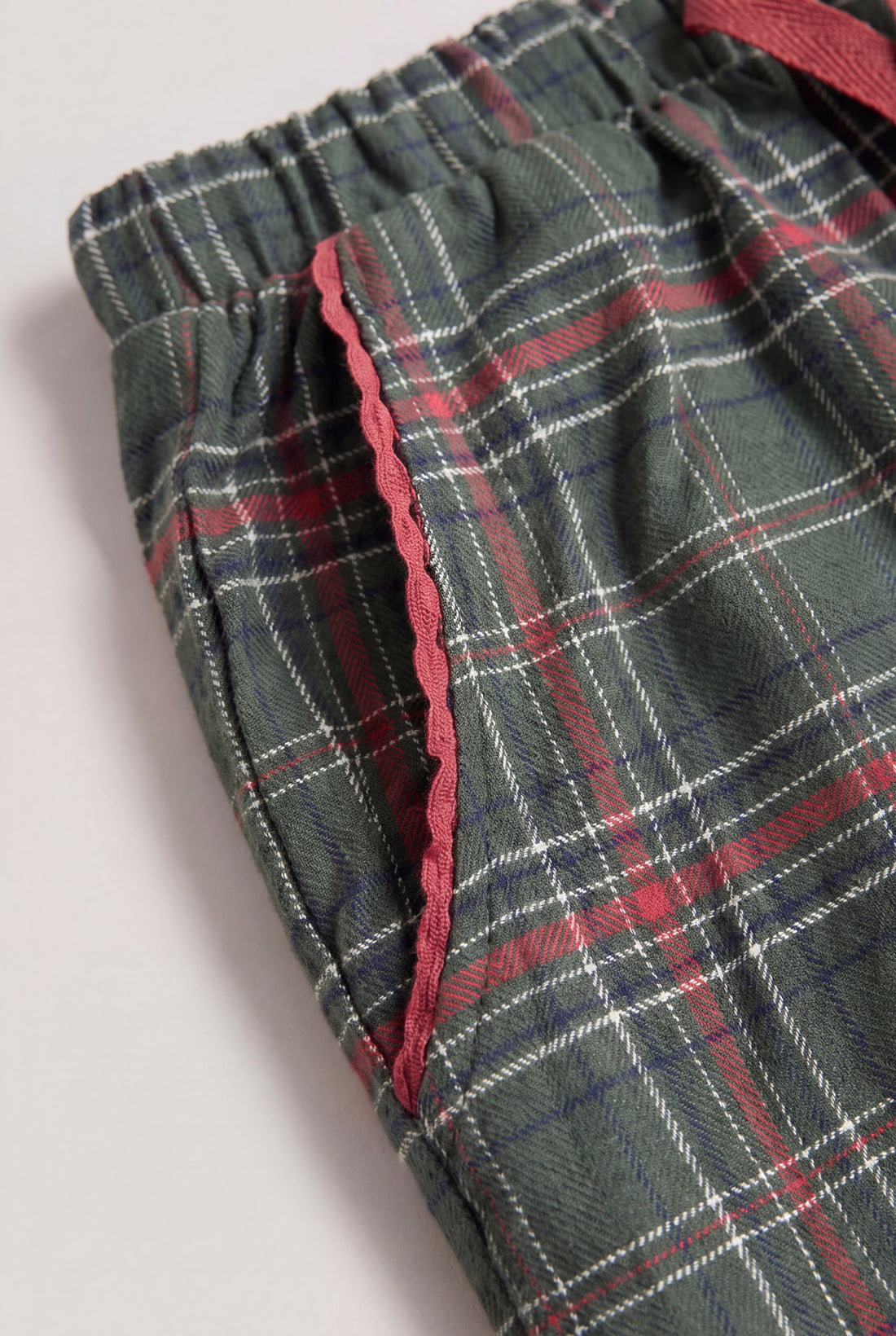 Pocket close-up: PTex Fashion green check trousers close-up of red scalloped pocket trim and brushed twill cotton