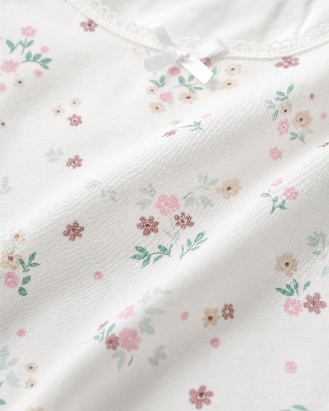 Girls white ditsy floral sleeveless tank top with lace trim neckline and satin bow, flat lay product photo