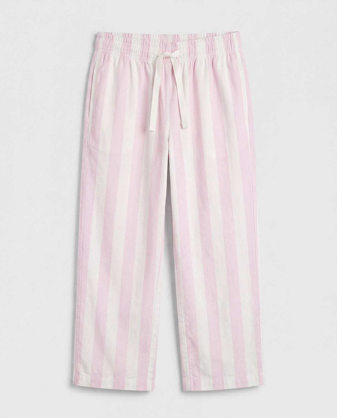 Close-up leg detail:
Close-up of girls' straight-cut palazzo pant leg panel showing bold blush pink and off-white vertical stripe woven cotton fabric with soft natural folds and clean single-needle hemline stitching.