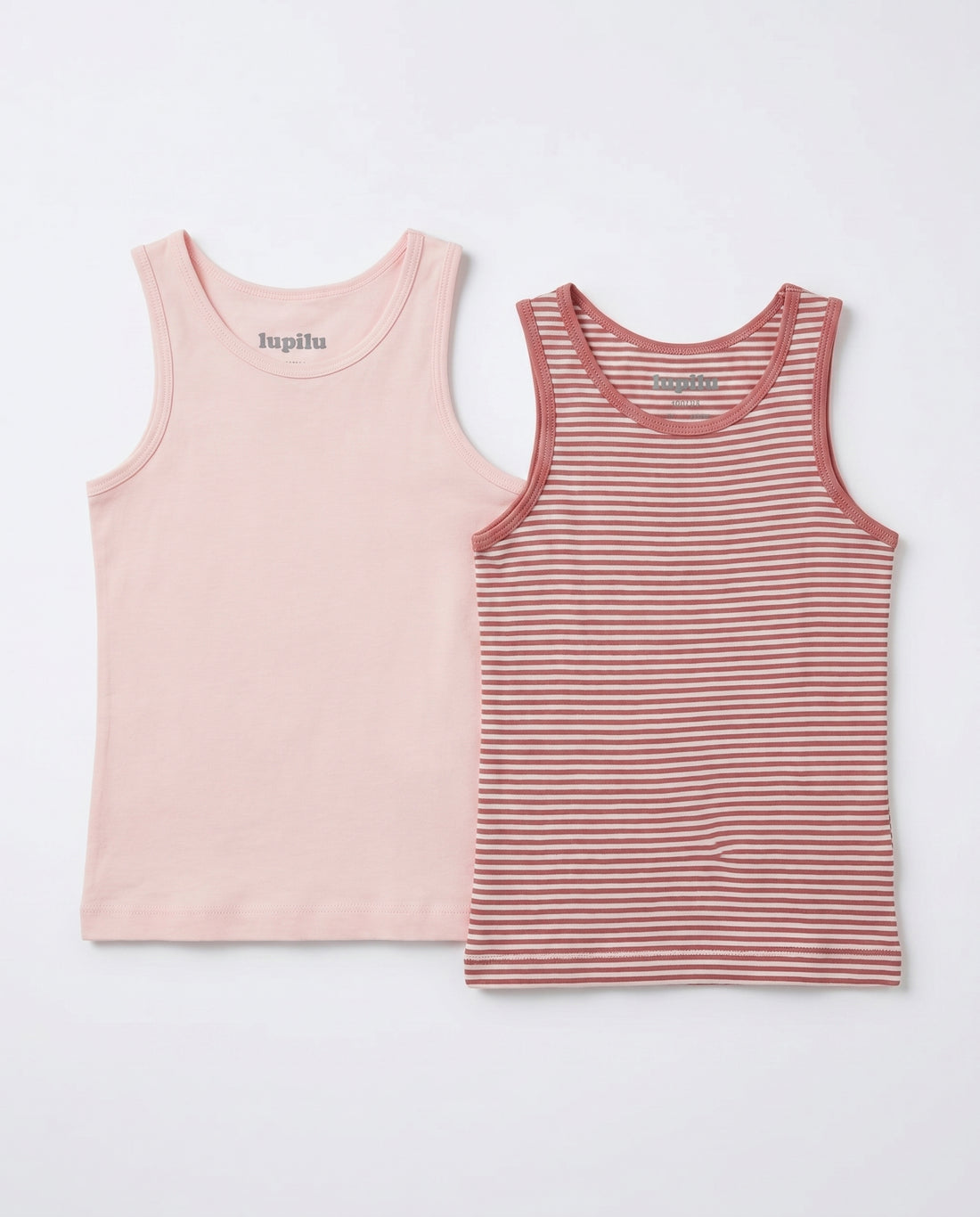 girls' 2-pack cotton tank top set displayed flat on a white background — solid soft pink scoop-neck tank on the left and rose-and-cream horizontal striped tank with contrast binding on the right, showing full silhouette and length.