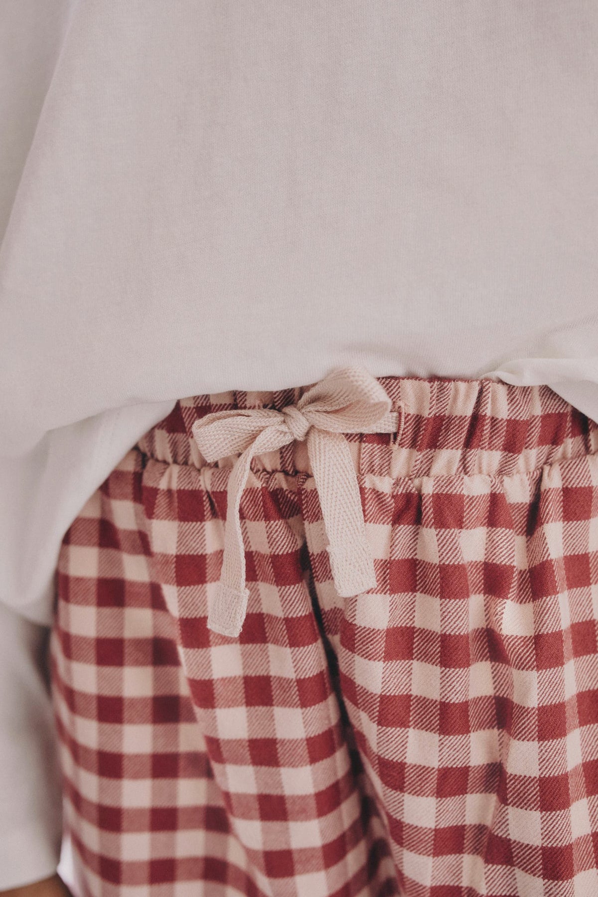 On-model waist detail: PTex Fashion girls' gingham woven trousers with elastic waistband and cream tie bow