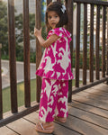 Girl wearing PTex Fashion magenta ikat print linen co-ord set with ruffle top and wide-leg pants, back view outdoors