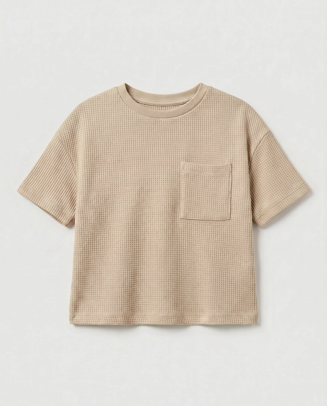 Full flat lay front view:
Kids' drop shoulder waffle cotton t-shirt in sand displayed flat lay on a white background, showing a relaxed boxy silhouette, ribbed crew neckline, short sleeves with ribbed cuffs, tonal chest patch pocket, and finished base hem.