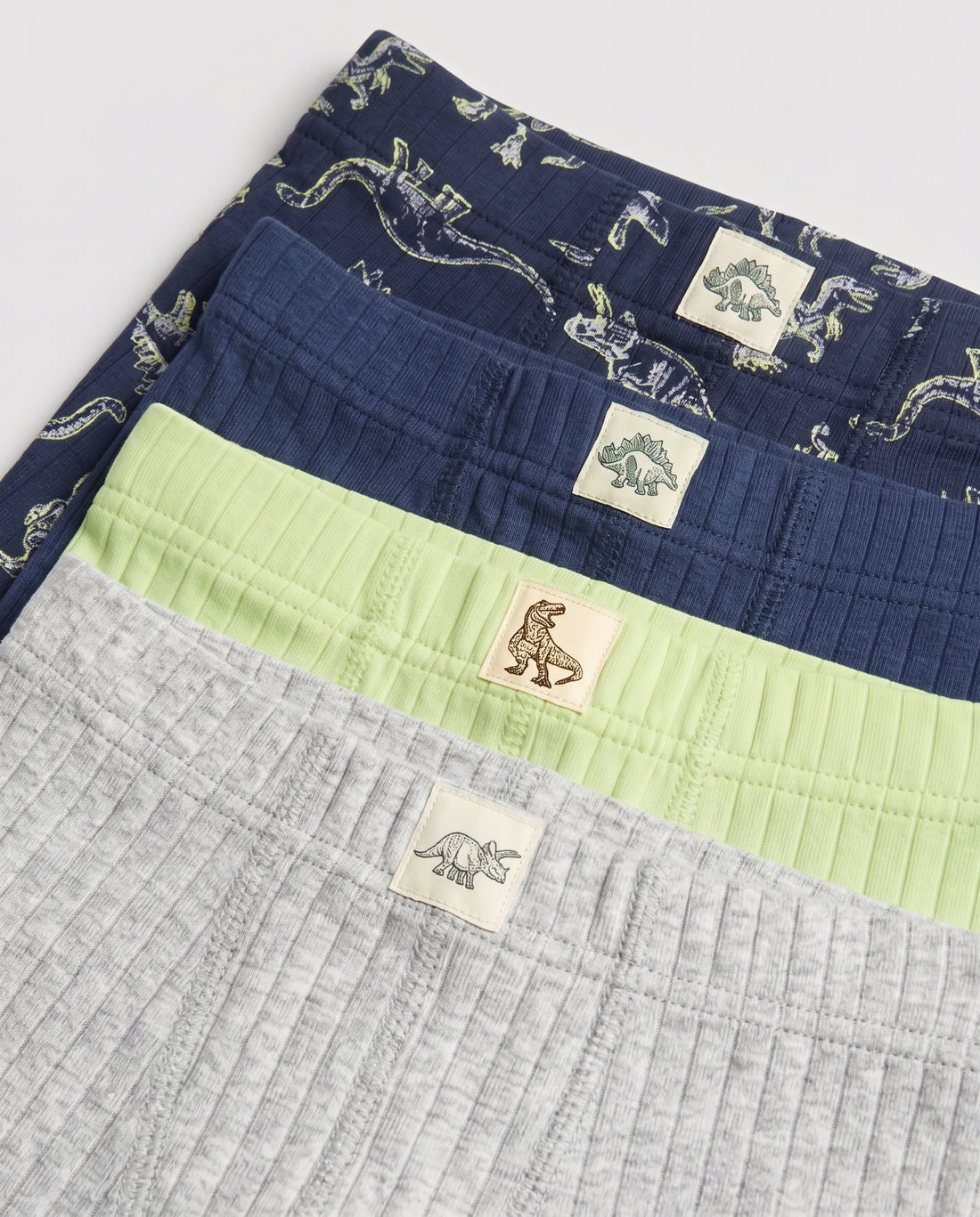  Pack of 5 boys' ribbed boxer briefs laid flat — grey marl, navy, lime green, white dino print, and navy dino print with dinosaur label patches