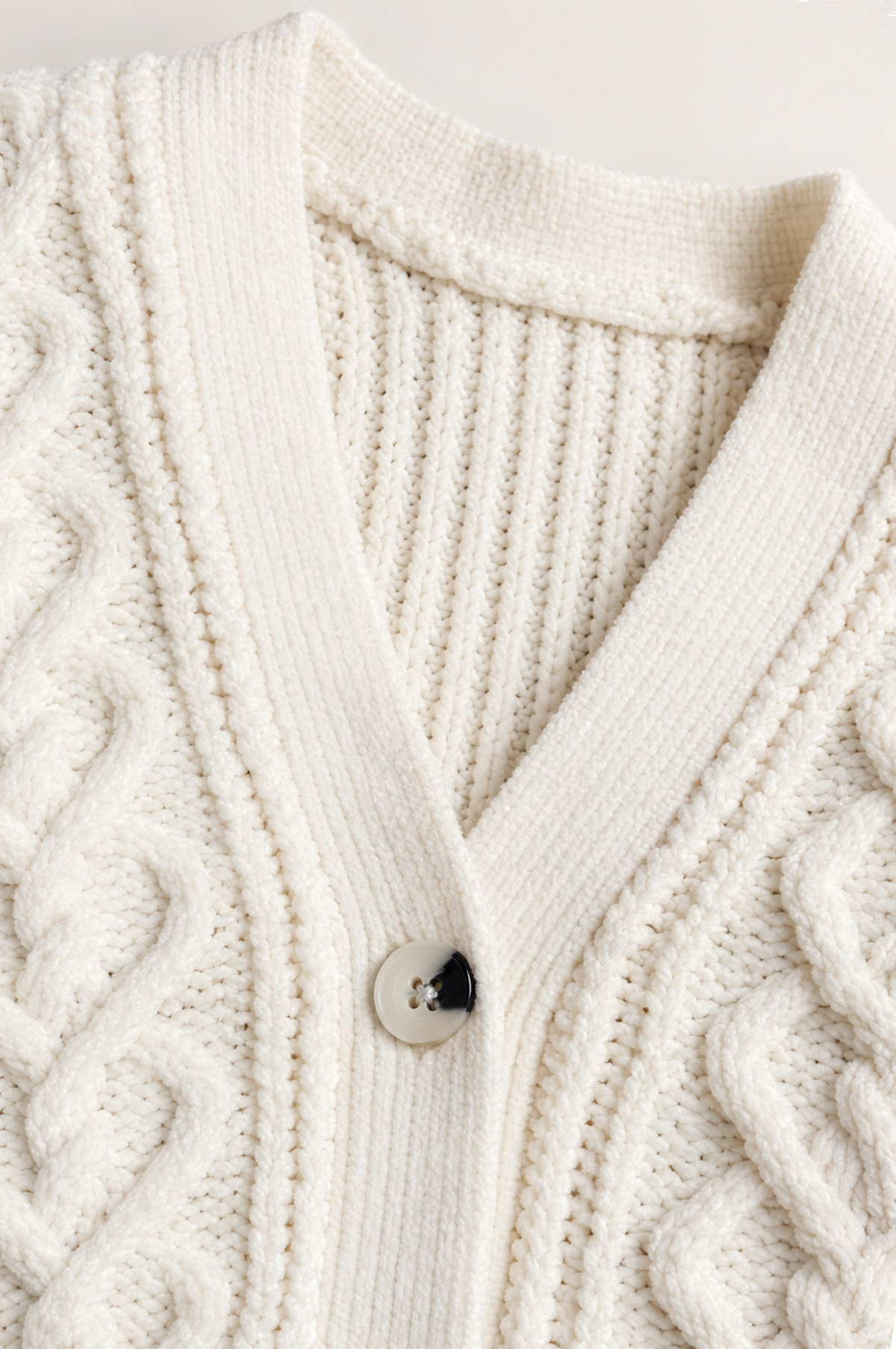 PTex Fashion girls’ ivory chenille cardigan close-up showing braided cable knit, ribbed V-neck and tortoiseshell-effect button