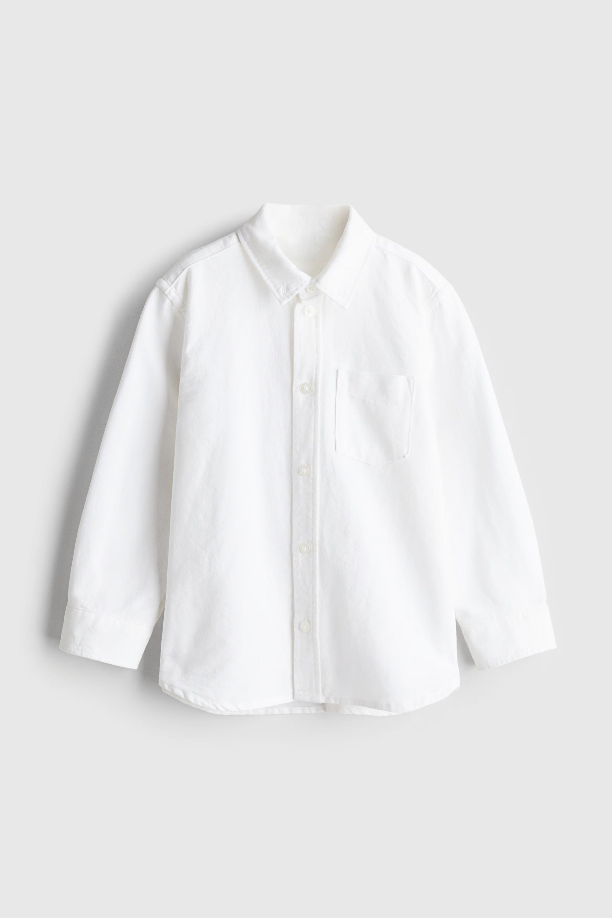 White toddler boys shirt on a light gray background