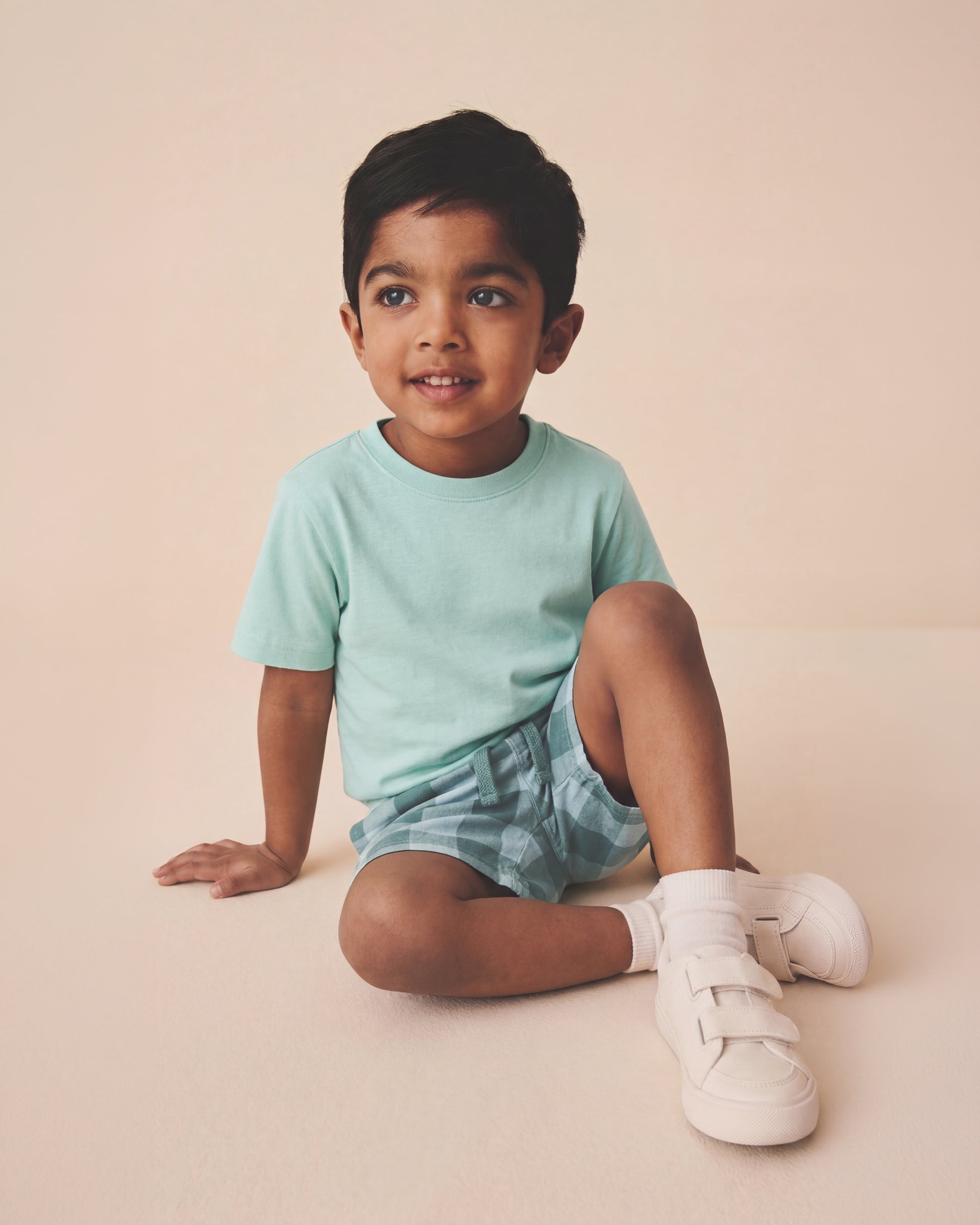 toddler boy wearing a mint blue t-shirt and short pant