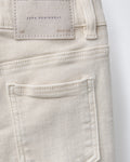 Back view detail of toddler denim Bermuda shorts featuring a structured back pocket and embossed leather brand patch on off-white denim.