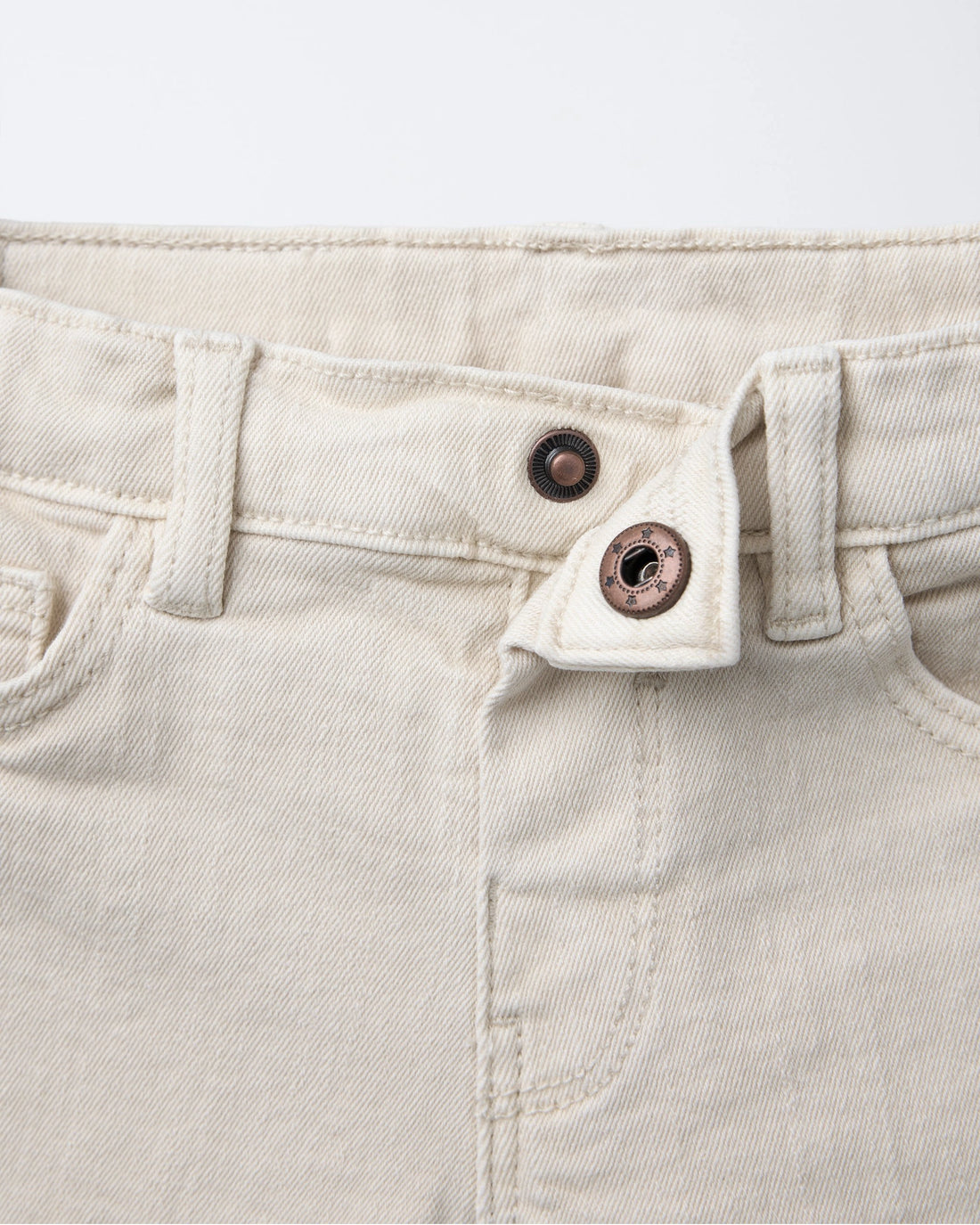 Full front view of  boys' off-white denim Bermuda shorts with 5-pocket design, silver rivet accents, and a clean straight-leg cut for toddlers.