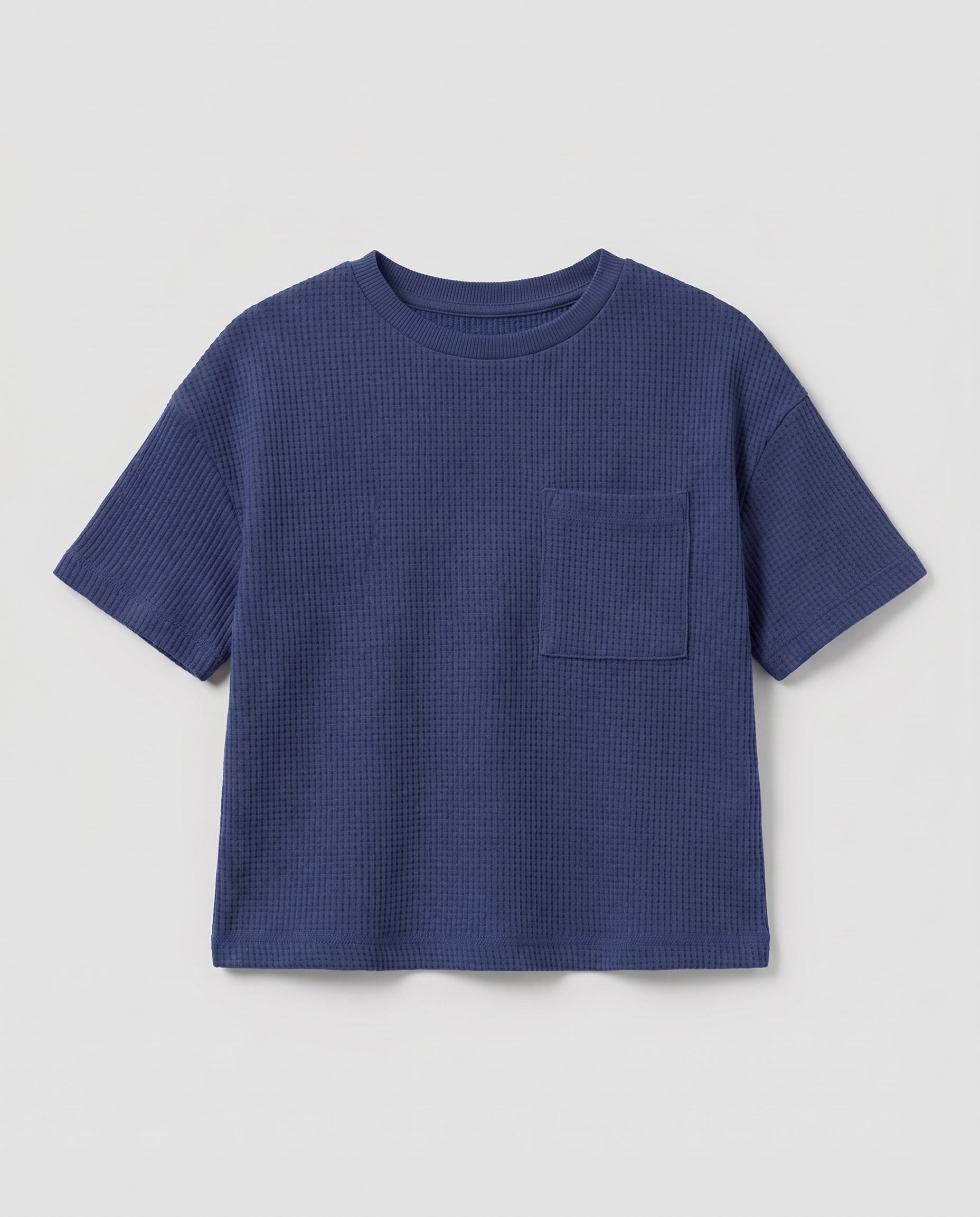 Full flat lay front view:
Toddler drop shoulder waffle knit t-shirt in navy blue displayed flat lay on a white background, showing a relaxed boxy fit, ribbed crew neckline, short sleeves with ribbed cuffs, and a single chest patch pocket.