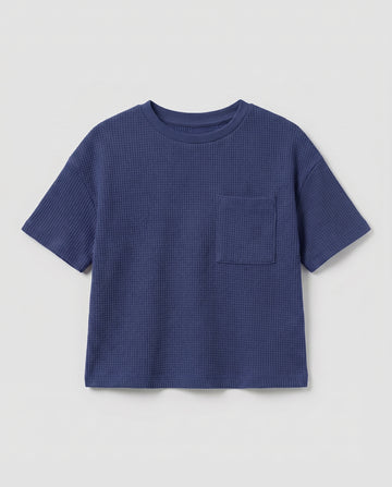 Full flat lay front view:
Toddler drop shoulder waffle knit t-shirt in navy blue displayed flat lay on a white background, showing a relaxed boxy fit, ribbed crew neckline, short sleeves with ribbed cuffs, and a single chest patch pocket.