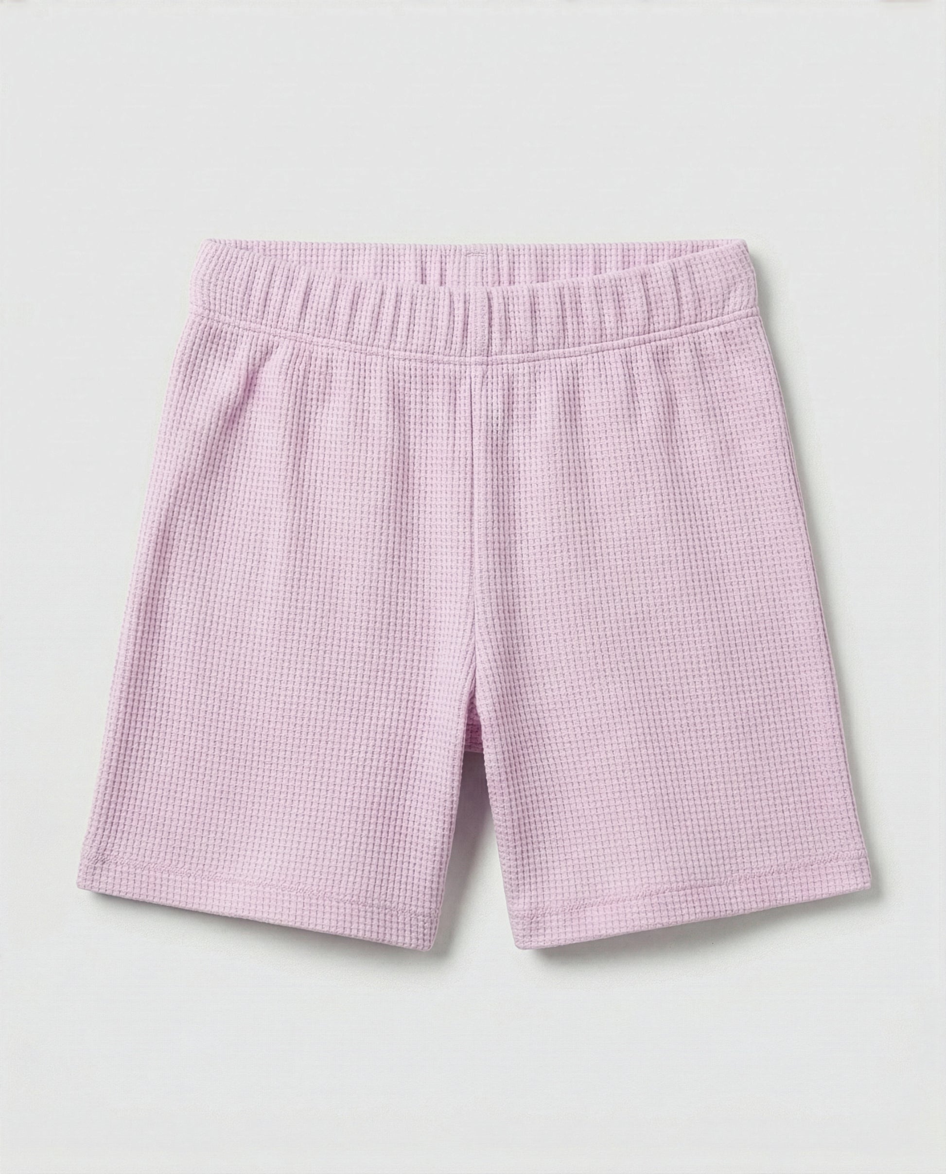 Toddler girls' waffle-knit cotton short pants in pink lilac with a wide elasticated waistband, laid flat on a light grey background.