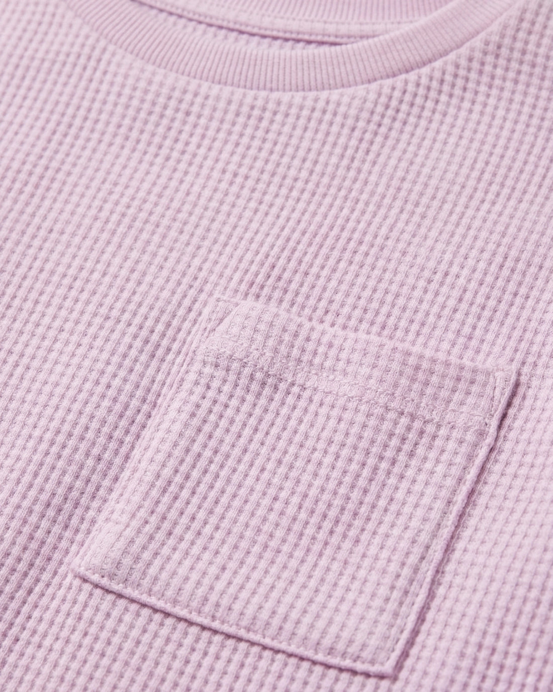 Toddler girls' waffle-knit cotton t-shirt in pink lilac with a ribbed crew neck, short sleeves, and a chest patch pocket, laid flat on a light grey background.