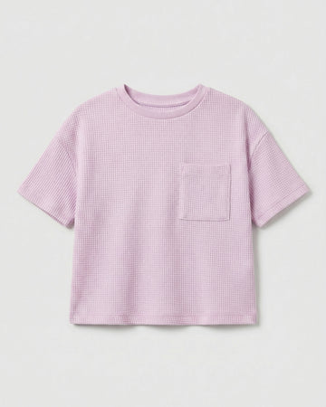 Toddler girls' waffle-knit cotton t-shirt in pink lilac with a ribbed crew neck, short sleeves, and a chest patch pocket, laid flat on a light grey background.