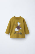 Olive long-sleeve kids’ t-shirt with a duck-on-scooter print and “Quack Quack” text. Relaxed fit, ribbed crew neck, soft jersey for everyday wear.